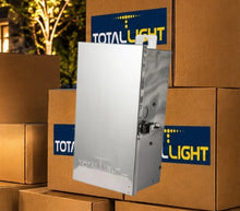 Load image into Gallery viewer, A silver metal outdoor light control box shown floating in front of stacked brown cardboard boxes with blue and yellow TotalLight logos.