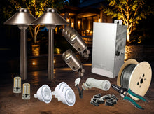 Load image into Gallery viewer, Outdoor landscape lighting kit with two ground-mounted metal bollard lights, two angled spotlights, a silver metal junction box, LED bulbs, white downlights, wire spool, and wire strippers, arranged on a patio with a blurred nighttime garden background.
